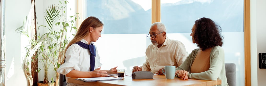 A couple meets with a financial advisor at a bright table to discuss charitable giving vehicles.